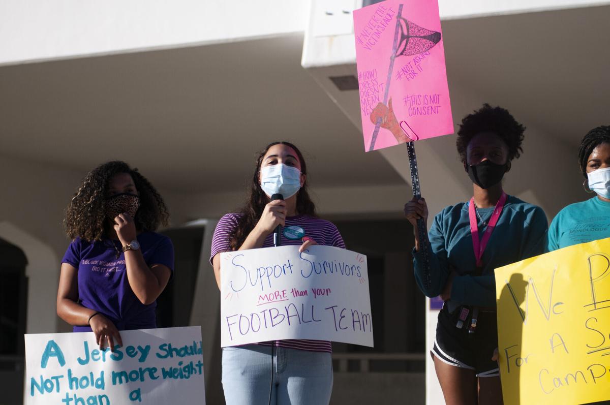Four female students, including Alaysia, engage in a Title IX protest. Each student is wearing a protective face mask.