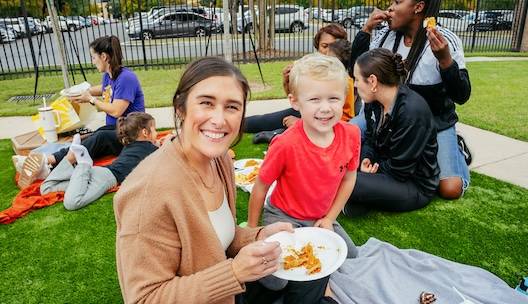 Mother and son sitting on blanket in grass