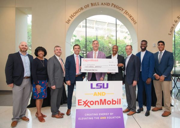 Nine people hold a large check for $2M from ExxonMobil.