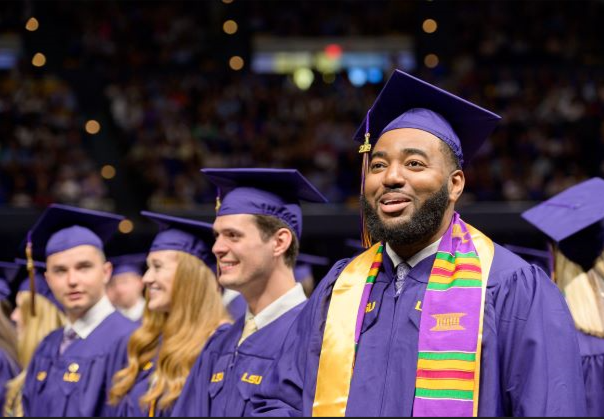 Group of studnets in purple caps and gowns at graduation ceremony