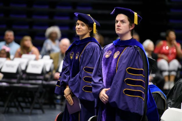 Two PhD students at commencement.