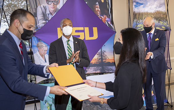 Presentation of promotion and tenure certificate by President Tate, Provost Lee, and Dean Llorens. 