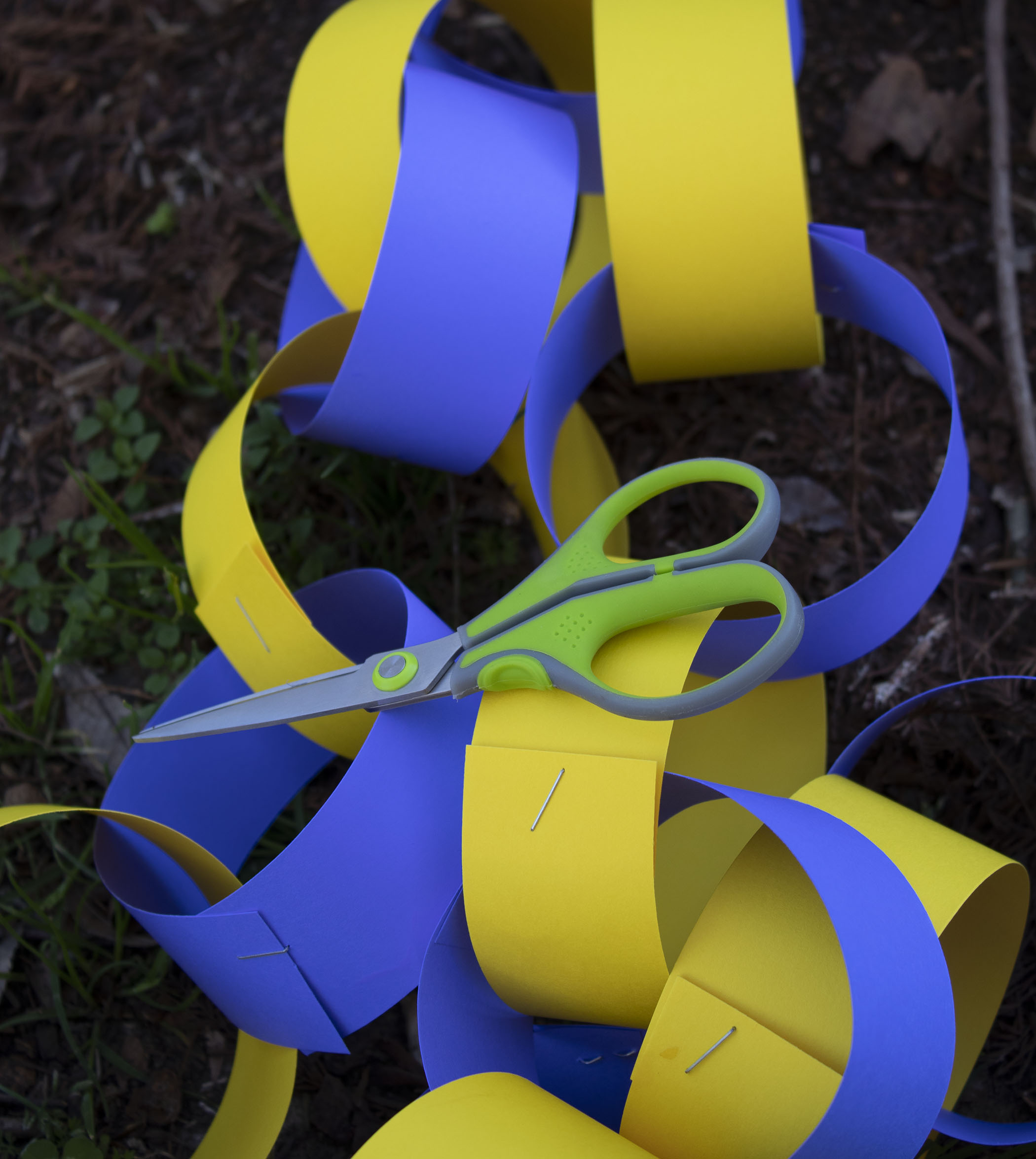 purple and gold construction paper loop chain with a pair of children's safety scissors on top