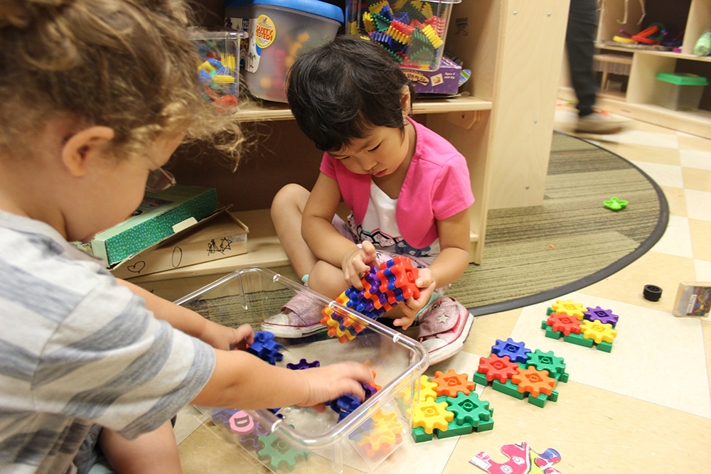 Photo of young children playing with building blocks.