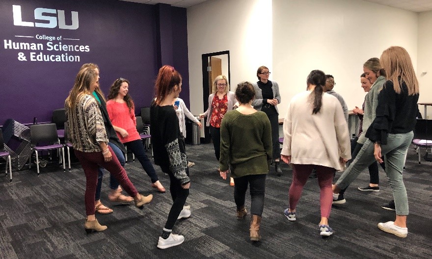 LSU education students participate in class activity where they stand in a circle and put one foot inside the circle