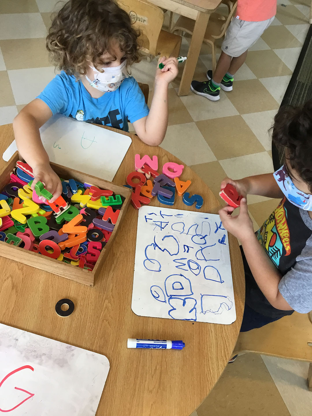 two children at the writing station at a preschool