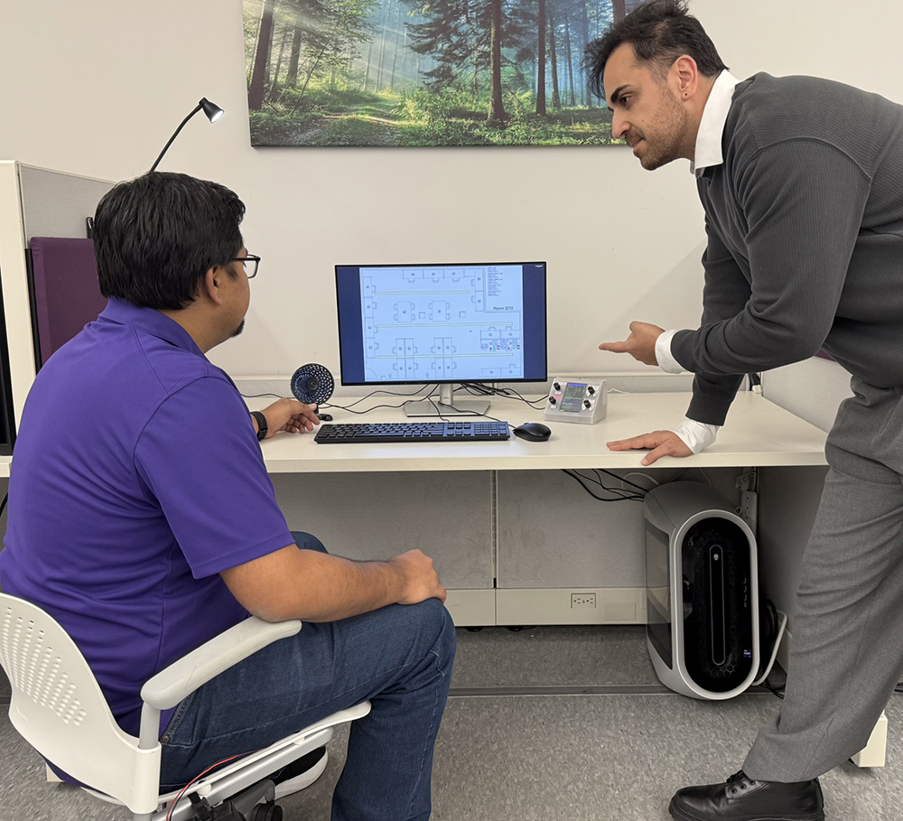 Amir Jafari instructs a student at a computer