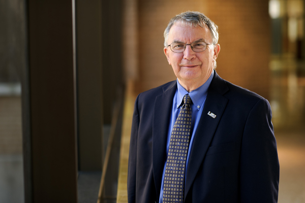 Dr. James Richardson smiles on staircase. 