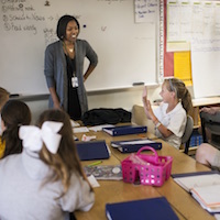 Students listen to teacher in elementary classroom.