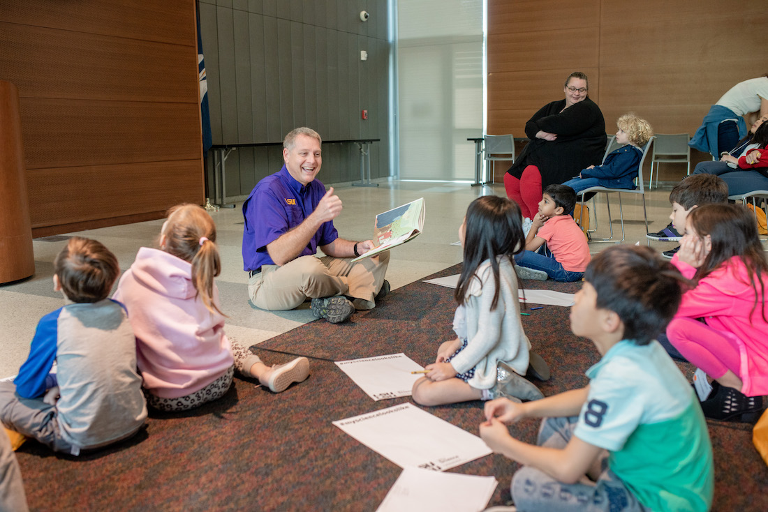 Dr. Kyle Harms reading to a group of kids for a STEM Story Time event.